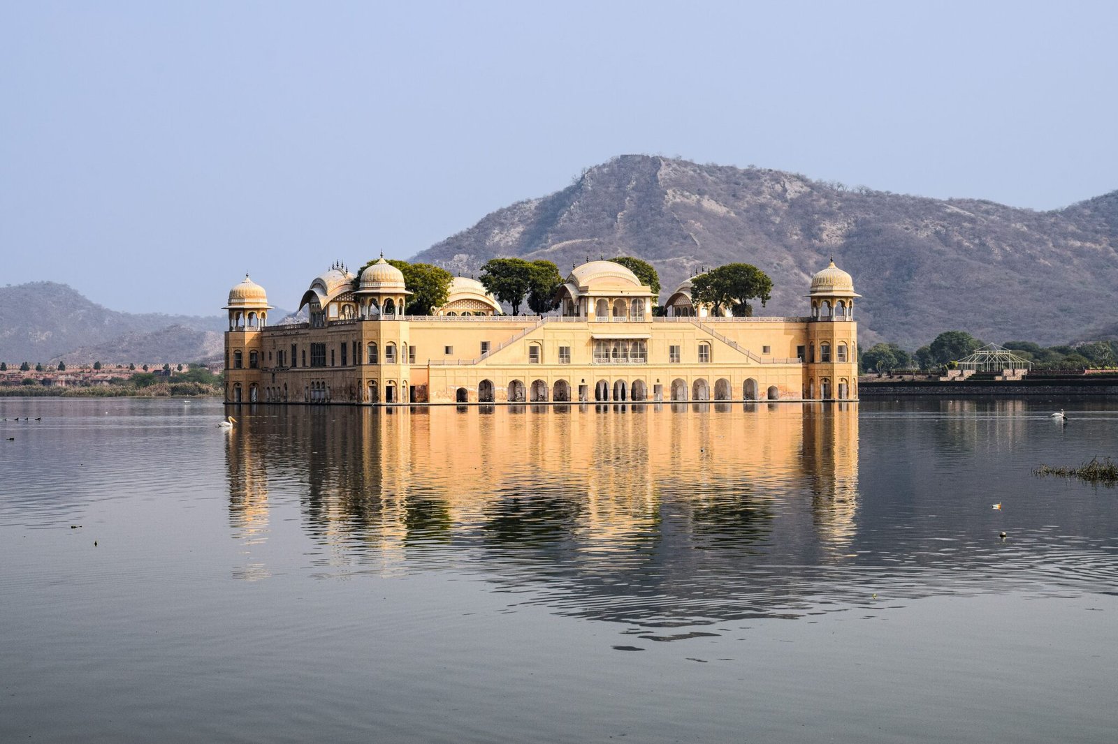 Jal Mahal, the water palace in Jaipur, reflecting in Man Sagar Lake with serene mountain backdrop.