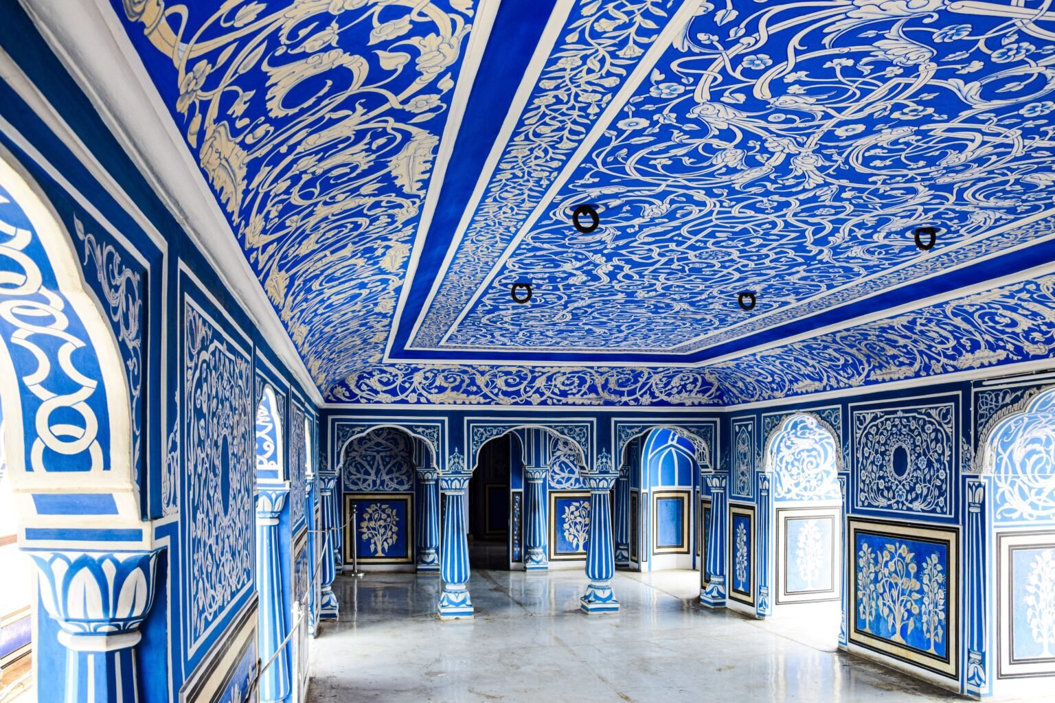 Explore the ornate blue interior of a historic landmark in Jaipur, showcasing stunning architectural details and vibrant design.