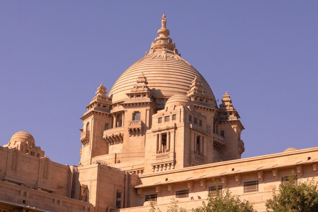 A stunning view of Umaid Bhawan Palace under a clear blue sky in Jodhpur, India.