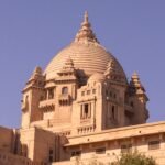 A stunning view of Umaid Bhawan Palace under a clear blue sky in Jodhpur, India.